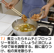 煮立ったらキムチとブロッコリーを加え、こしょうと淡口しょうゆで味を調整する。器に盛りつけ、松の実を散らす。