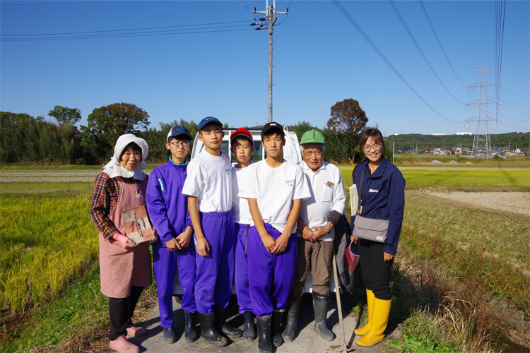 緑の帽子の男性とピンクのエプロンの女性がホストファミリーの谷口さん夫妻。広島の中学生と西河さんと一緒に写真撮影。